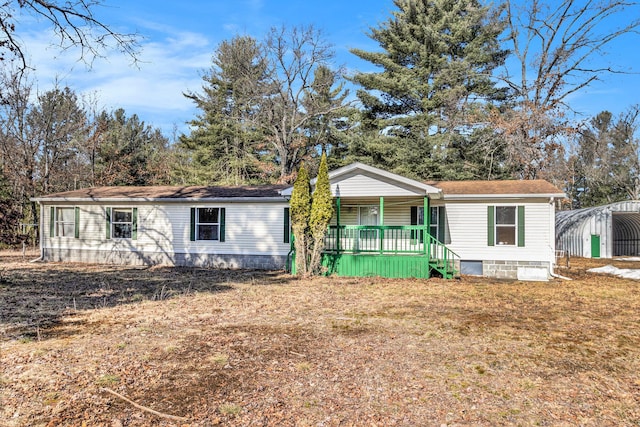 manufactured / mobile home featuring crawl space, a porch, and a front lawn