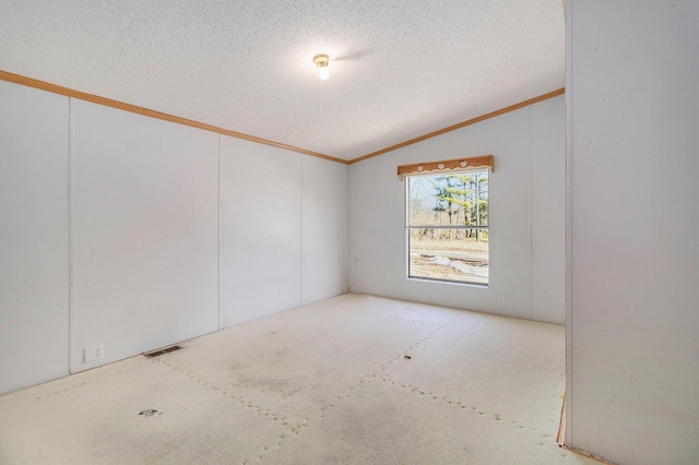 empty room with visible vents, a textured ceiling, lofted ceiling, and ornamental molding