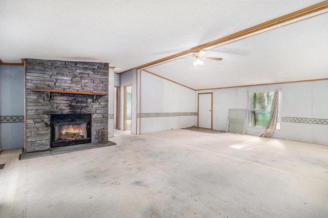 unfurnished living room featuring a ceiling fan, a textured ceiling, a fireplace, crown molding, and vaulted ceiling