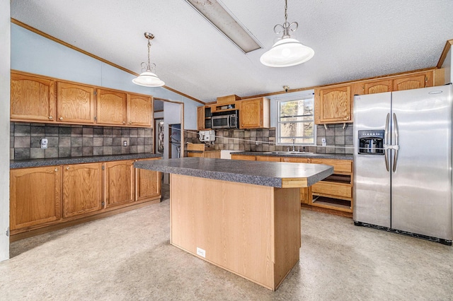 kitchen with a sink, decorative backsplash, vaulted ceiling, appliances with stainless steel finishes, and dark countertops