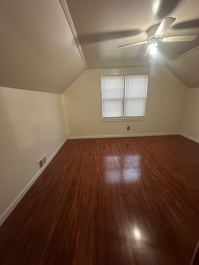 additional living space featuring vaulted ceiling, visible vents, baseboards, and dark wood-style flooring