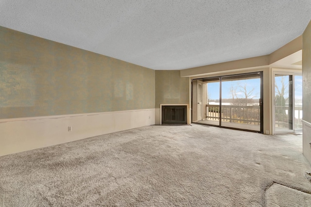 unfurnished living room featuring a textured ceiling and carpet flooring