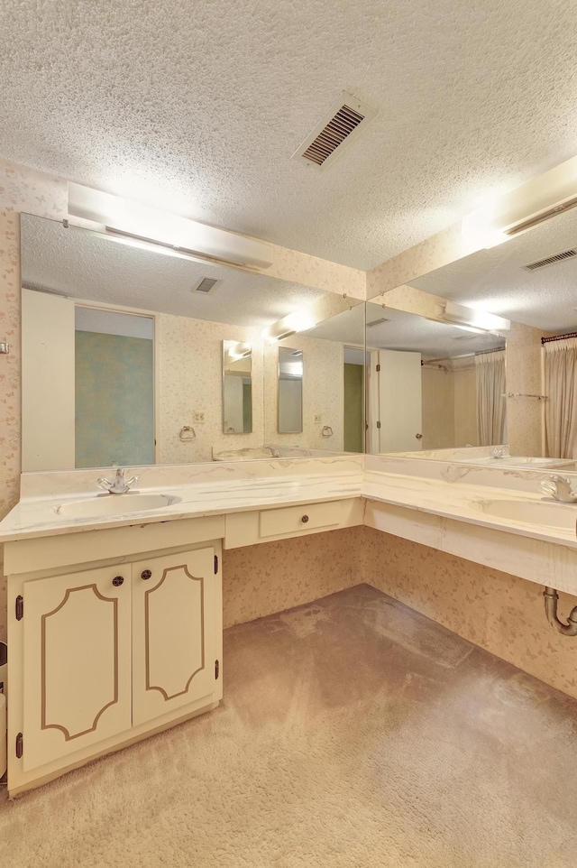 full bath with a textured ceiling, visible vents, and a sink