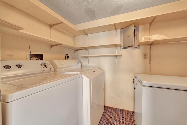 clothes washing area featuring laundry area, electric panel, separate washer and dryer, and a textured ceiling