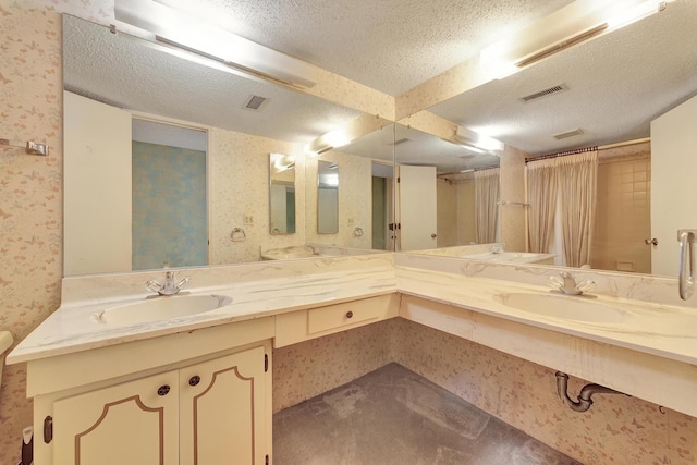 full bathroom with wallpapered walls, a textured ceiling, visible vents, and a sink