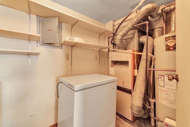 interior space featuring electric panel, a textured ceiling, water heater, and laundry area