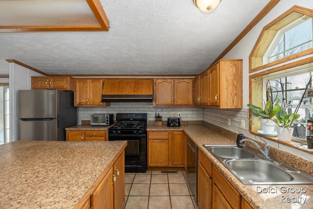 kitchen with custom exhaust hood, ornamental molding, stainless steel appliances, and a sink