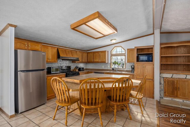 kitchen featuring backsplash, premium range hood, vaulted ceiling, ornamental molding, and black appliances