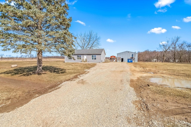 view of front of house featuring an outbuilding and dirt driveway