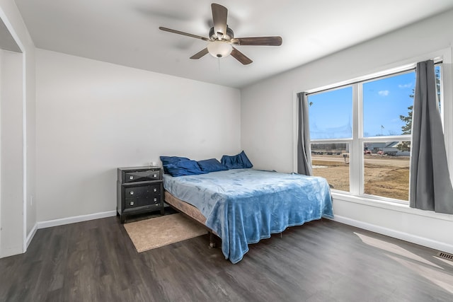 bedroom featuring ceiling fan, baseboards, and wood finished floors