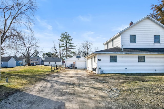 view of property exterior featuring an outbuilding, driveway, and a detached garage