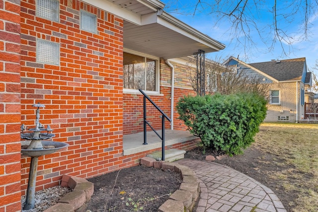 doorway to property featuring brick siding