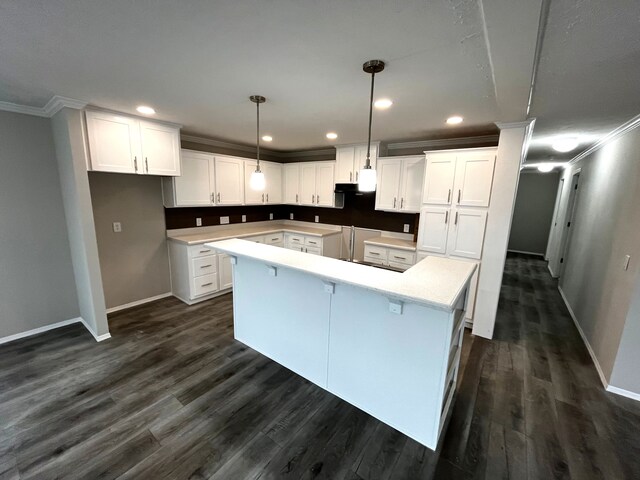 kitchen featuring a center island, dark wood-type flooring, baseboards, and ornamental molding