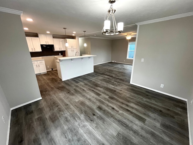 kitchen with white cabinets, open floor plan, dark wood-style flooring, and ornamental molding