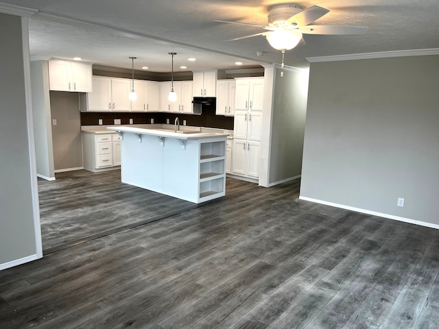 kitchen with baseboards, crown molding, and white cabinetry