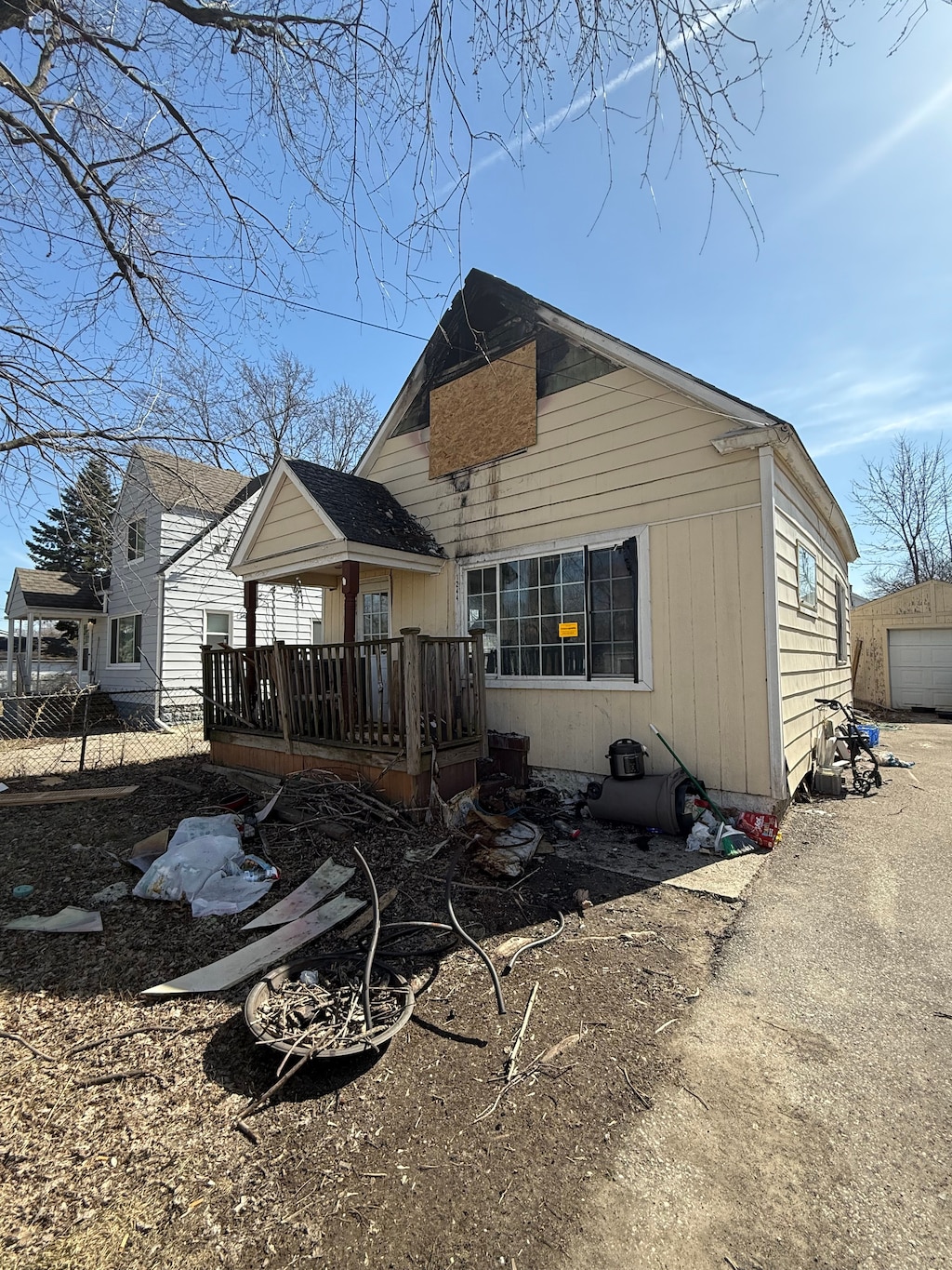 rear view of house with a wooden deck and a detached garage