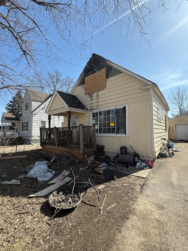 rear view of house with a wooden deck and a detached garage