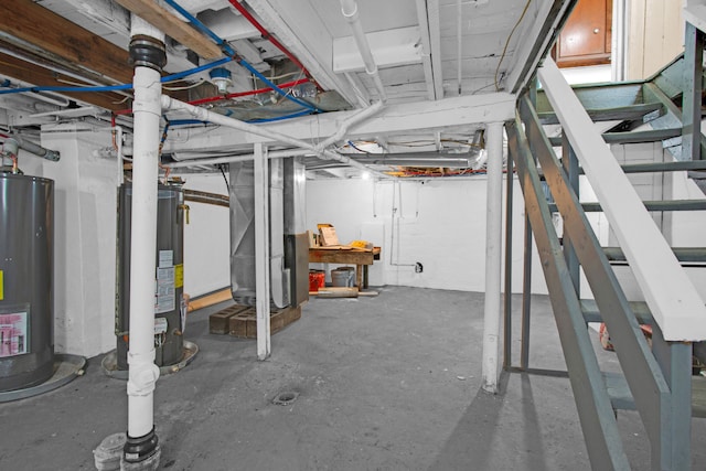 unfinished below grade area featuring stairway, heating unit, and water heater