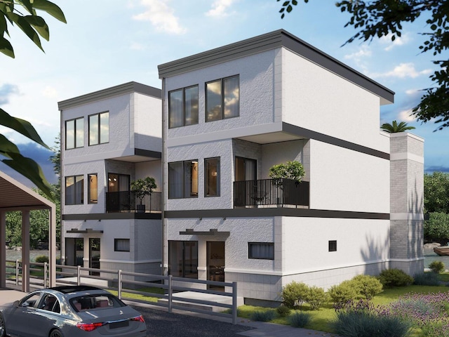 view of front facade with stucco siding and fence