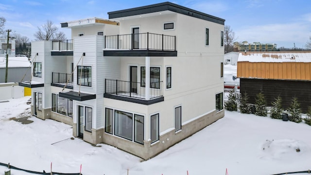 view of snowy exterior with stucco siding