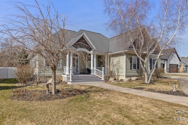 view of front of property with covered porch, driveway, a front yard, and fence