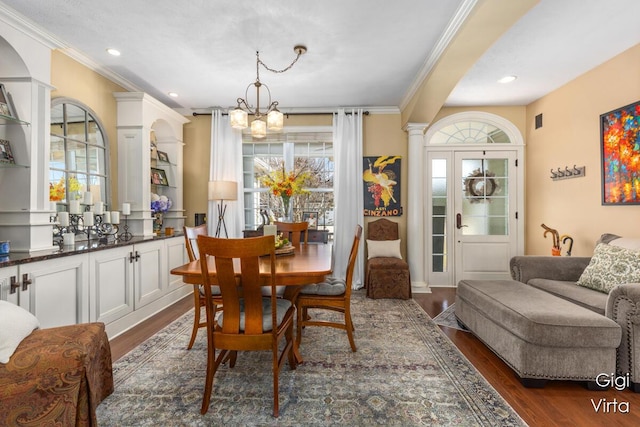 dining area with dark wood finished floors, a healthy amount of sunlight, and decorative columns