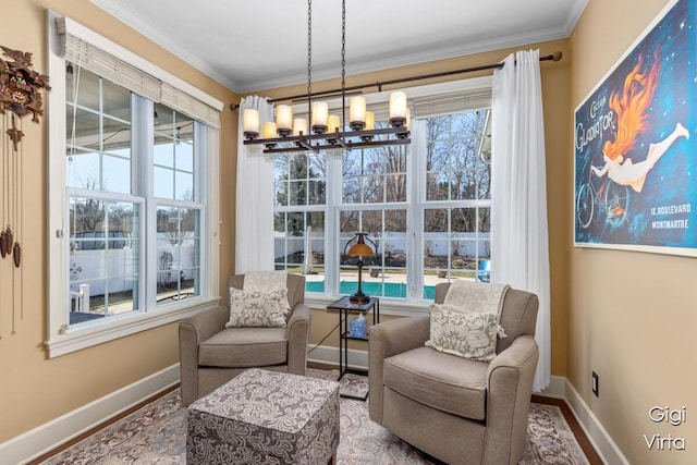 living area featuring a notable chandelier, plenty of natural light, and ornamental molding