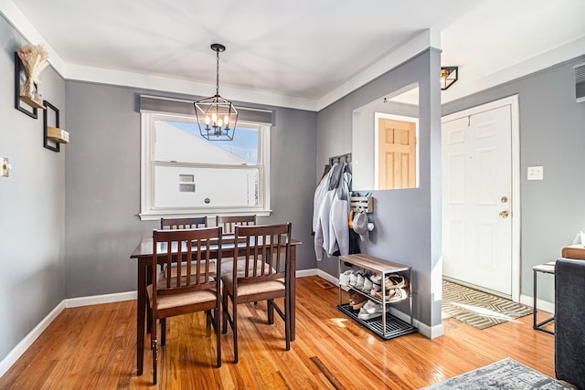 dining space with a chandelier, light wood-style flooring, and baseboards