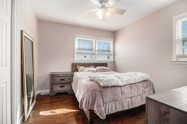 bedroom with dark wood-type flooring, multiple windows, baseboards, and ceiling fan