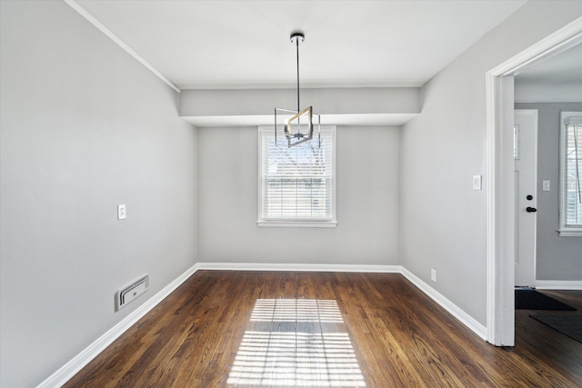 unfurnished dining area with visible vents, a healthy amount of sunlight, dark wood-type flooring, and baseboards