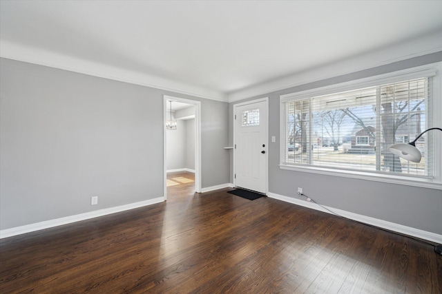 foyer entrance featuring baseboards and dark wood-type flooring