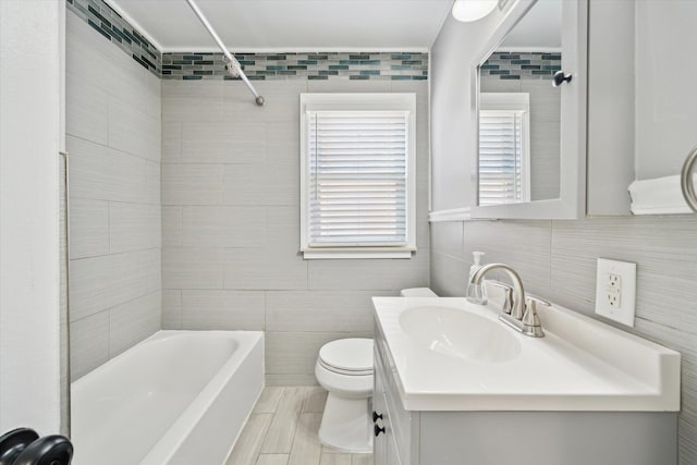 full bathroom featuring vanity, tile walls, toilet, and shower / bathtub combination