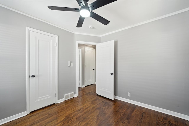 unfurnished bedroom featuring a ceiling fan, visible vents, dark wood-style floors, baseboards, and ornamental molding