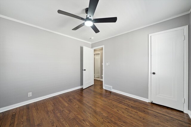 unfurnished bedroom featuring baseboards, visible vents, dark wood finished floors, ceiling fan, and ornamental molding