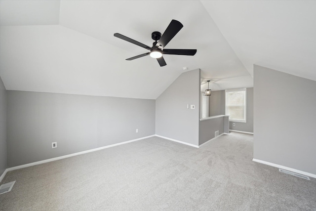 additional living space with vaulted ceiling, carpet flooring, visible vents, and baseboards