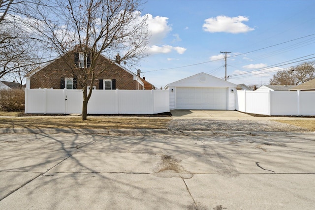 exterior space with an outdoor structure, a gate, a garage, and a fenced front yard