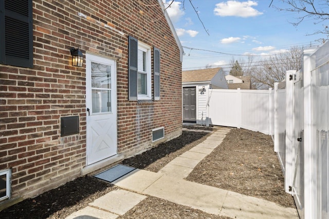 property entrance with brick siding and fence