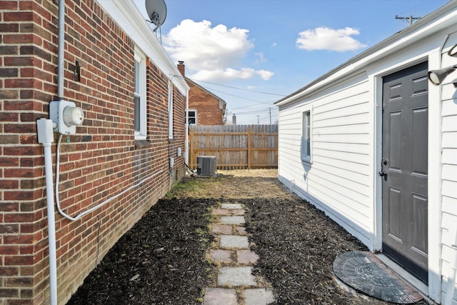 view of yard with central air condition unit and fence