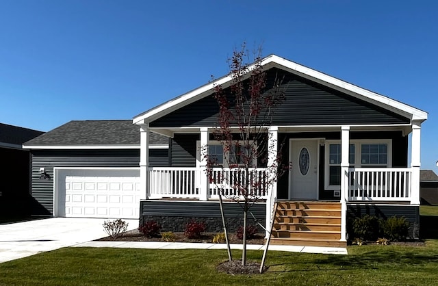 view of front facade featuring a porch, concrete driveway, a garage, and a front lawn