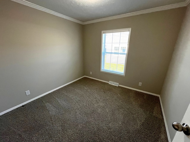 spare room featuring baseboards, visible vents, dark colored carpet, and ornamental molding