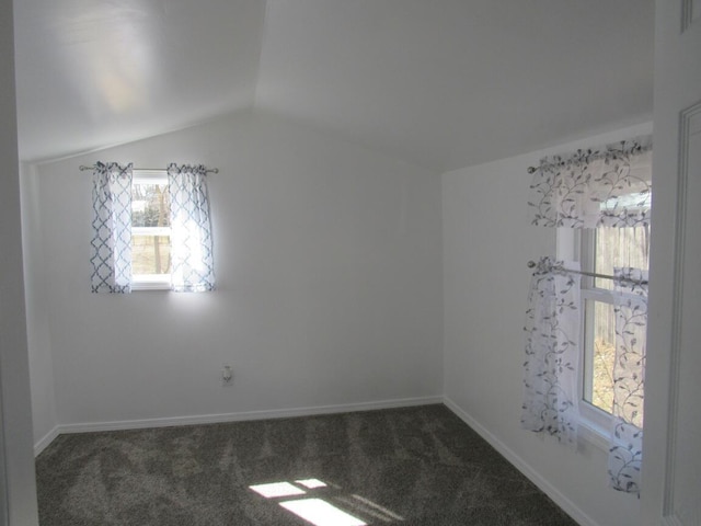 spare room featuring vaulted ceiling, baseboards, and carpet floors