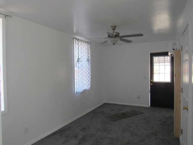 carpeted empty room with ceiling fan and baseboards