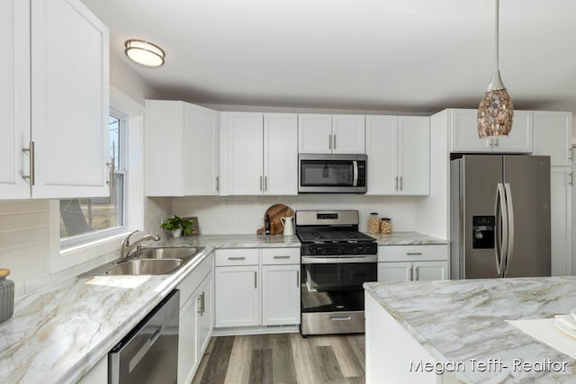 kitchen featuring appliances with stainless steel finishes, white cabinetry, and a sink