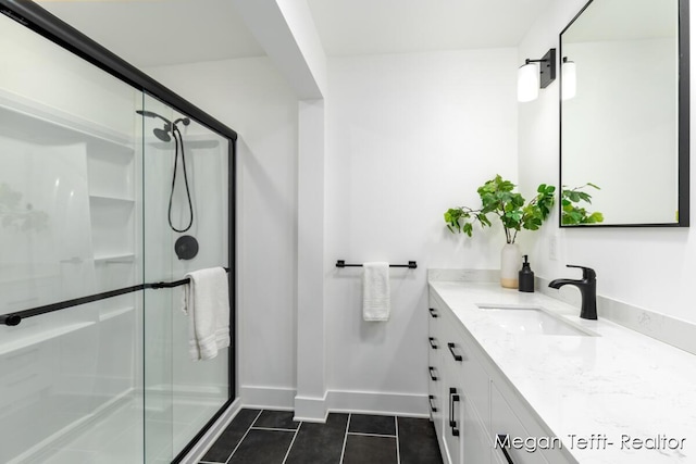 bathroom with baseboards, a stall shower, vanity, and tile patterned flooring