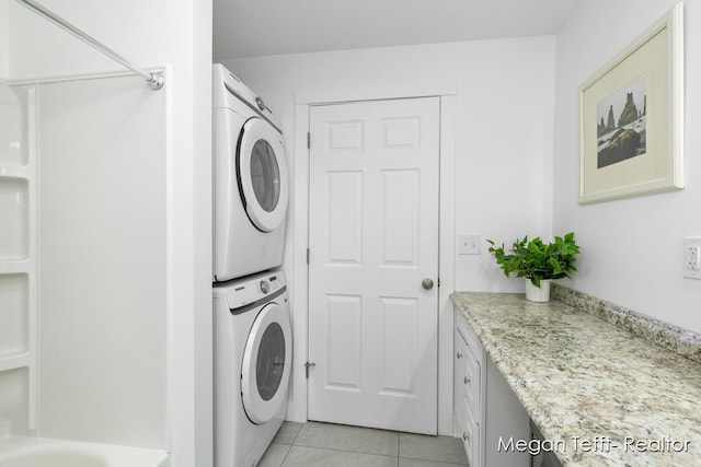 laundry area with light tile patterned floors, laundry area, and stacked washer and clothes dryer