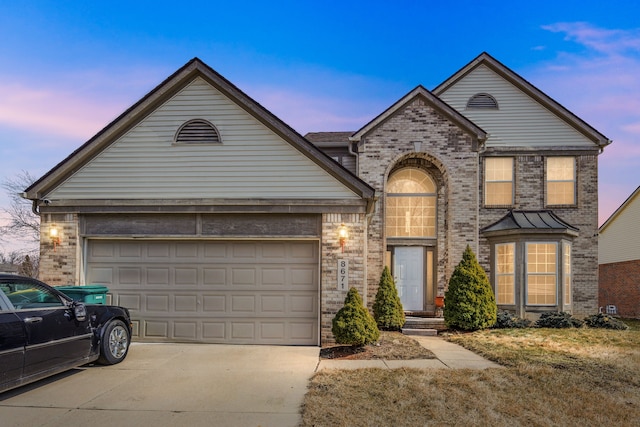 traditional home with concrete driveway, a garage, and brick siding