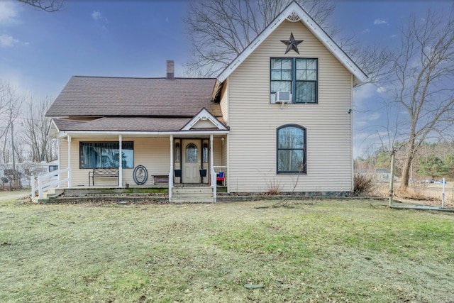 view of front of property with a shingled roof, a front yard, covered porch, cooling unit, and a chimney