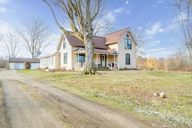 view of front facade featuring a front yard, covered porch, and dirt driveway