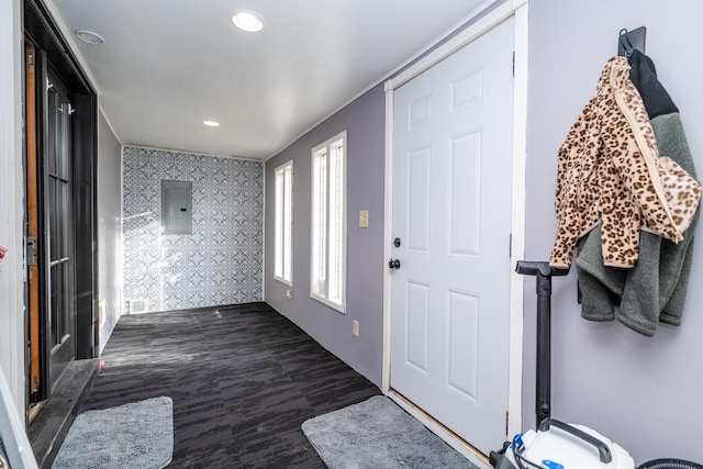 foyer entrance with dark wood finished floors, wallpapered walls, electric panel, recessed lighting, and an accent wall