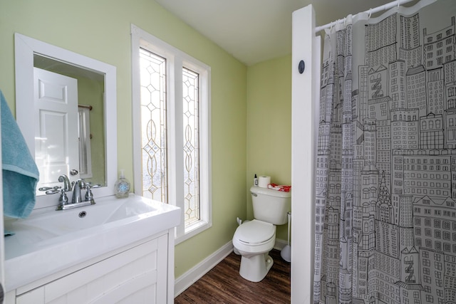 bathroom with a shower with shower curtain, toilet, wood finished floors, and a wealth of natural light